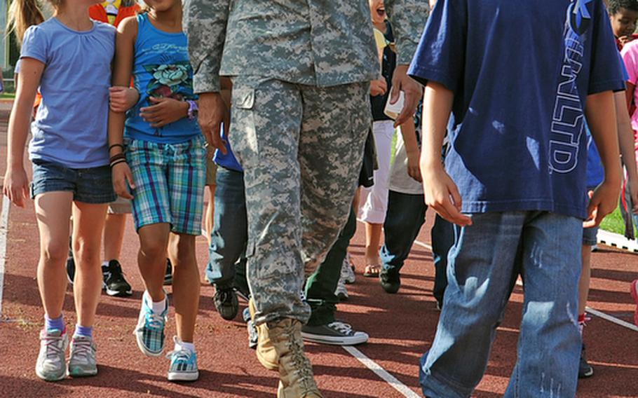U.S. Army Europe commander Lt. Gen. Mark Hertling walks around the track with Patrick Henry Elementary School students Tuesday morning after he and his wife kicked off "Fueling the Future," a health and nutrition initiative at the Heidelberg, Germany school. Sue Hertling led the students through an exercise routine to start off the morning.