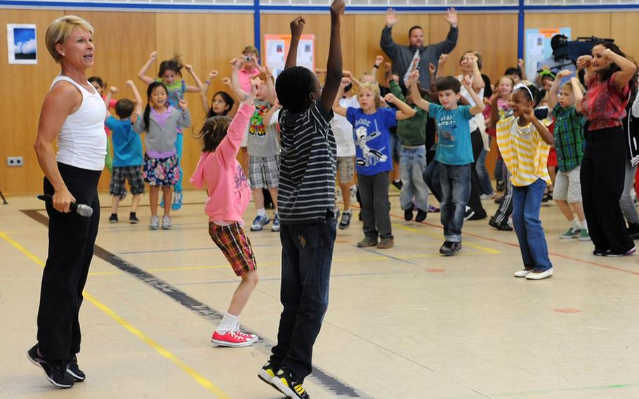Sue Hertling, wife of U.S. Army Europe commander Lt. Gen. Mark Hertling leads Patrick Henry Elementary School students through an exercise routine at the school Tuesday morning. She and her husband were at the Heidelberg, Germany, school to kick off "Fueling the Future," a health and nutrition initiative. "I think the kids should make the connection between stress management and movement", she said.
