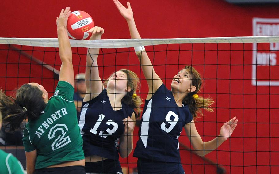 AFNORTH's Madison Puckett tries to get the ball over the net against the defense of Bitburg's Brandy Oliver, center, and Allison Lillemon. Bitburg won the match in Kaiserslautern Saturday, 25-21, 25-19, 24-26, 26-24.