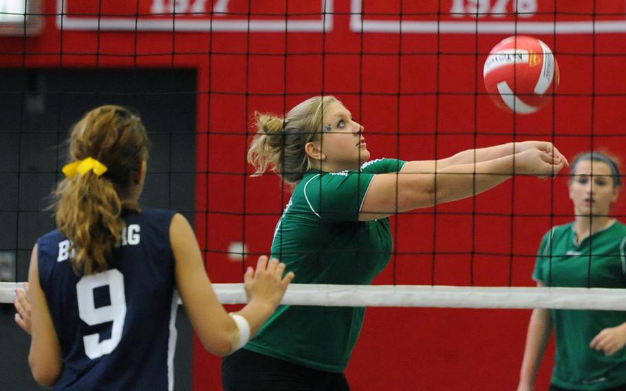 AFNORTH's Emma Phillips keeps her eyes on the ball as she returns a Bitburg shot in the Lions 25-21, 25-19, 24-26, 26-24 loss to the Barons at Kaiserslautern on Saturday. At left, Bitburg's Allison Lillemon waits for the play.