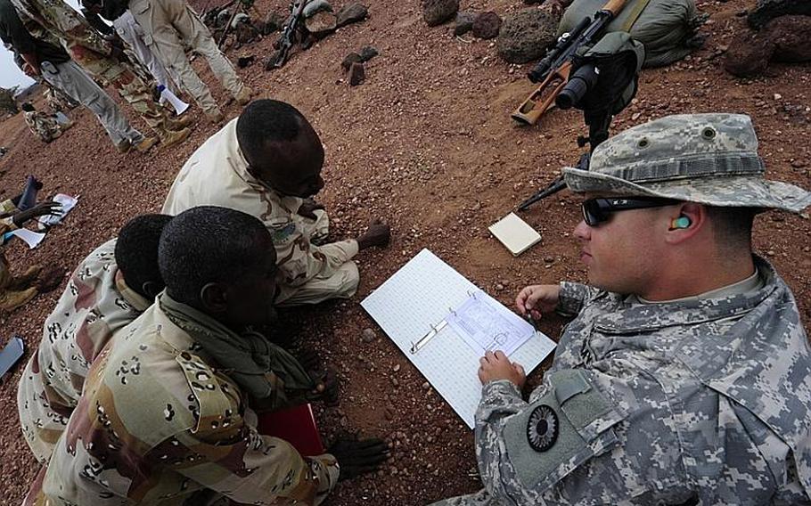 U.S. Army Sgt. Paul Herrick, right, shows Djiboutian soldiers how to be a spotter for a rifleman during an advanced marksmanship skills course at Camp Ali Ouney, Djibouti, in February 2011.