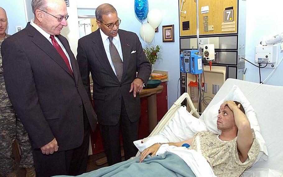 While recovering from bullet wounds received during the Nov. 5, 2009, shooting at Fort Hood, Spc. Matthew Cooke, receives a surprise visit from former Chief of Naval Operations Adm. Vernon Clark (ret.) and former Secretary of the Army Togo West, who were appointed by Secretary of Defense Robert Gates to head the Fort Hood shooting task force.