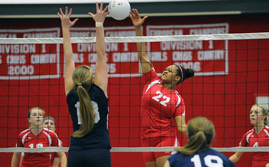 Kaiserslautern's Kalynn Richardson slams the ball over the net against the defense of Lakenheath's Eliza Evans in a Division I match at the DODDS-Europe volleyball championships. Kaiserslautern won the match 25-22, 20, 25, 25-19.