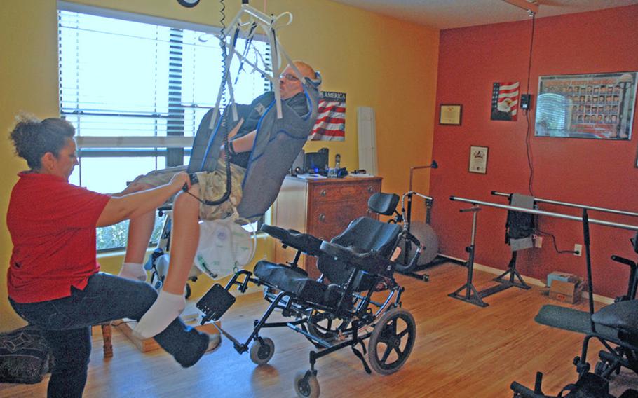 Erik's occupational therapist uses a track system in the ceiling to move him from the therapy table to his wheelchair.