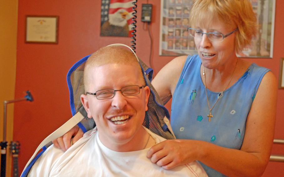 Christine Schei laughs with her son, Erik, during his therapy session in June 2012. She has pushed him to progress over the last seven years.