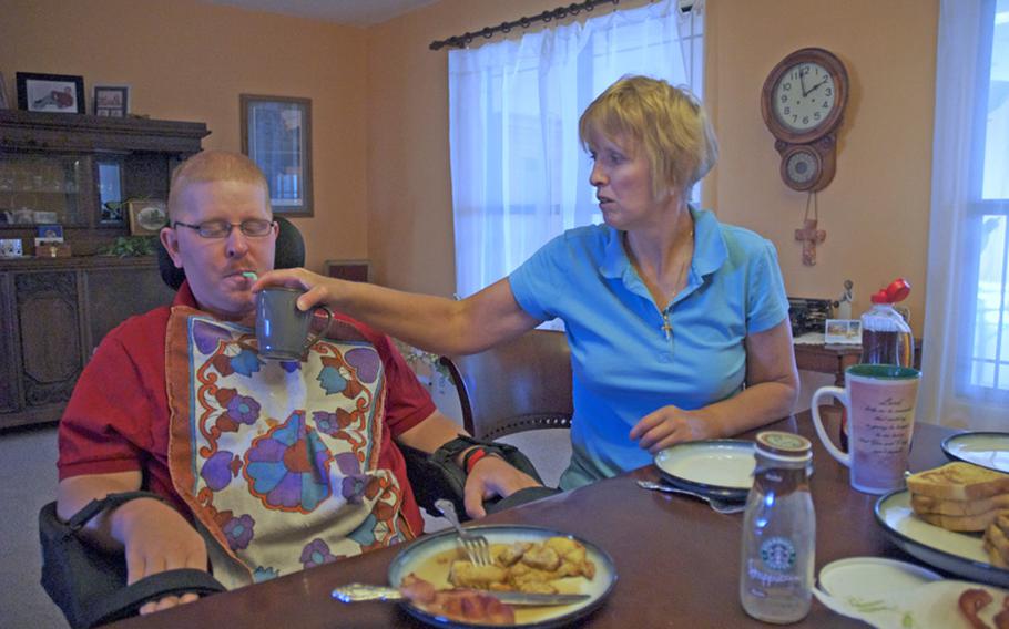 On a Saturday morning in June, Christine Schei's plate remains empty while she feeds her 28-year-old son, Erik, breakfast. Erik was shot in the head in Iraq in 2005 and has little use of his body.