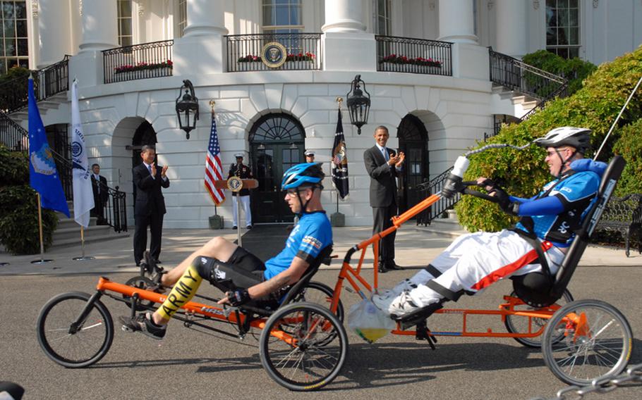 Erik Schei, far right, during the Soldier Ride at the White House in the spring. The medically retired Army sergeant, who was shot in the head in Iraq, is pulled by his brother, Spc. Deven Schei, on a specially made bicycle. Deven was wounded in Afghanistan.