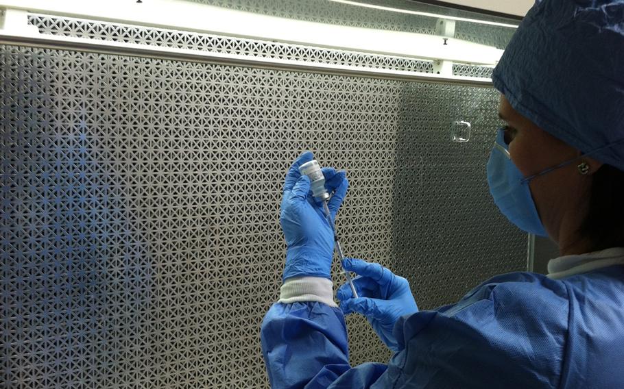 Sherri Thomas, research nurse at the Cancer Vaccine Development Program combine a specific immunogenic peptide with a stimulator under a sterile hood at Brooke Army Medical Center in San Antonio, Texas. 
