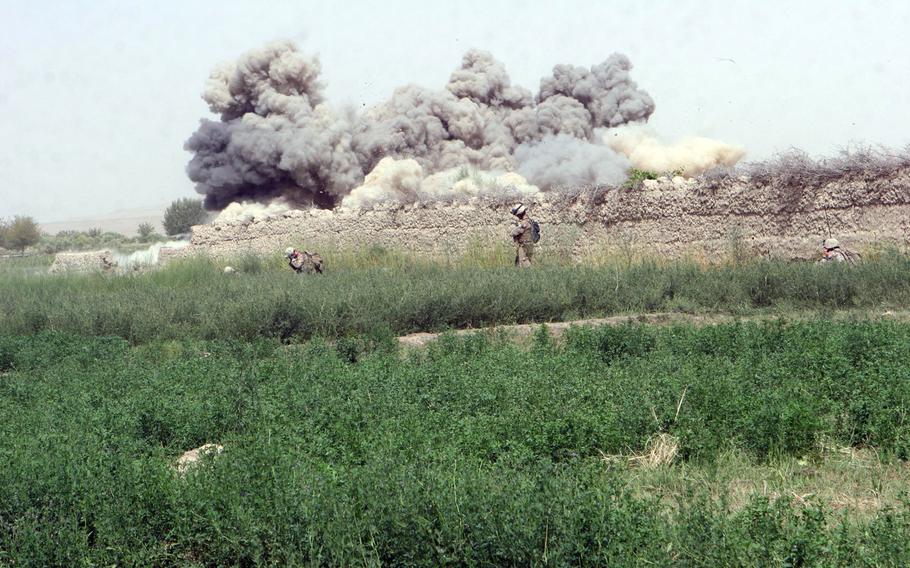 Marines with Company E, 2nd Battalion, 8th Marine Regiment, conduct a controlled detonation on the Herati wall in Afghanistan's Helmand province  Aug. 15, 2009.  Insurgents used the compound for cover and concealment during several firefights.