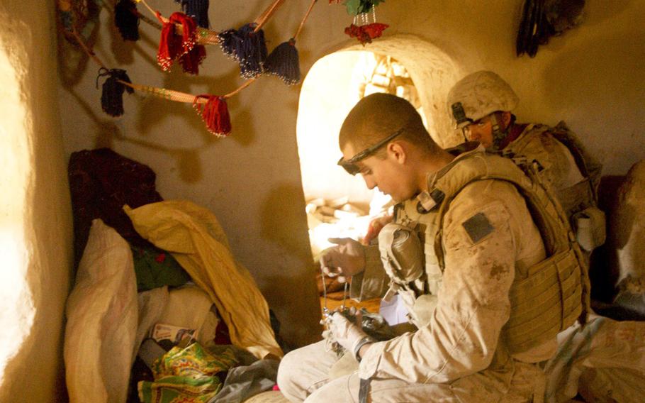 Marines with Combined Anti Armor Team 1, 1st Battalion, 5th Marine Regiment, look through piles of clothes after discovering illegal drugs and improvised explosive device making material while searching a compound in Nawa District, Helmand province, Afghanistan, Oct. 19, 2009. Marines were attacked while conducting a security patrol in the area. CAAT 1 and Marines with Weapons Company, 1/5, conducted a two day operation to clear out local villages known to be used by enemy insurgents and to rid commonly traveled roads of IEDs.