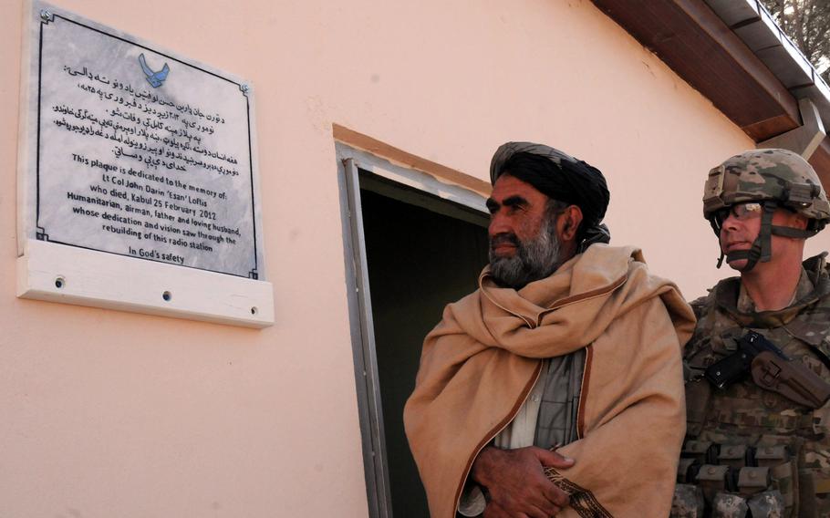 U.S. Air Force Lt. Col. Justin Kraft, commander of the Zabul Provincial Reconstruction Team, and Bismullah Lodin, a radio station official, reads a plaque at FOB Smart, Afghanistan, dedicated in memory U.S. Air Force Lt. Col. John Darin Loftis, who died Feb. 25, 2012 from wounds received during an attack in Kabul.