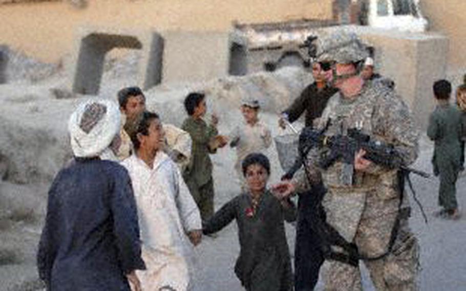 Then-Maj. John Loftis, a public information officer deployed from Hurlburt Field, Fla., interacts with local children in Afghanistan in 2009.