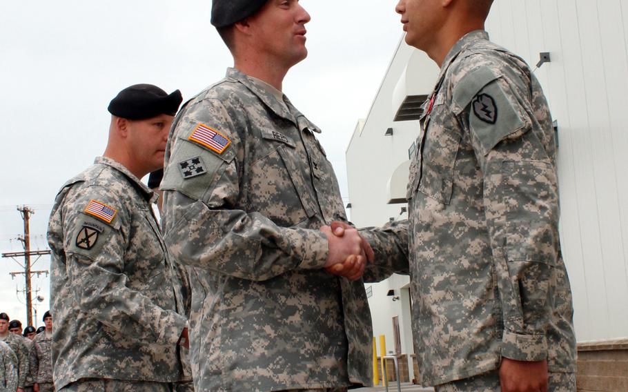 Col. Brian Reed, commander of the 1st Stryker Brigade Combat Team, 25th Infantry Division, congratulates Sgt. Stephen Stoops, a soldier in the brigade's 1st Battalion, 24th Infantry Regiment, after awarding him the Bronze Star with "V" device for his response to an "insider attack" on a base in Afghanistan's Zabul Province in January 2012.