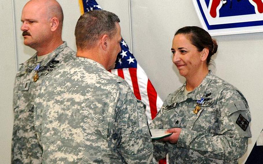 Maj. Gen. Mark A. Milley, Fort Drum and 10th Mountain Division (LI) commander, presents the Distinguished Flying Cross to Sgt. Julia A. Bringloe, a flight medic with C Company Dustoff, 3rd Battalion, 10th Aviation Regiment, 10th Combat Aviation Brigade, during a ceremony Sept. 7 at Wheeler-Sack Army Air Field. Ten aviators received awards for valor during the ceremony, for heroic actions they performed in Afghanistan in 2010-2011.