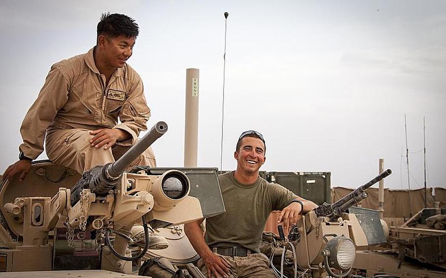 U.S. Marine Corps Lance Cpl. Phillip Lim, left, and Cpl. Brandon Baber, both assigned to Delta Company, 1st Tank Battalion, Regimental Combat Team 7, take a pause from conducting function checks on an M1A1 Abrams tank on Camp Shir Ghazay, Helmand province, Afghanistan.