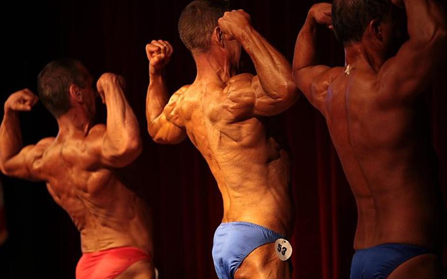 Male body builders show off their biceps and back muscles for judges Saturday in the 2013 Bodybuilding and Figure Invitational in Kaiserslautern.
