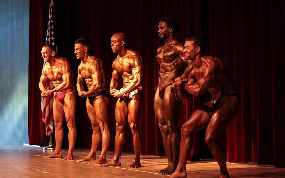 Male heavyweight competitors show their most muscular pose to the judges and the crowd the 2013 Bodybuilding and Figure Invitational in Kaiserslautern.