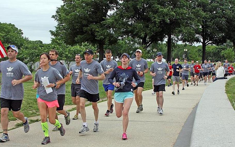 Former CIA director David Petraeus, center, and VA assistant secretary Tommy Sowers, his left, take part in the "Run as One" event in Washington, D.C., on May 18.