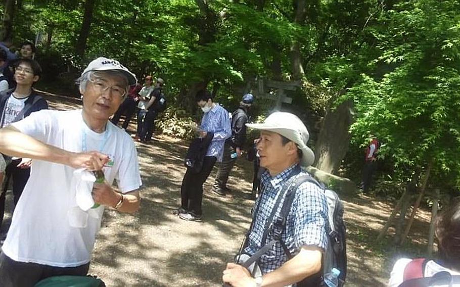 Volunteer guides Tadashi Saito and Susumu Kondo take a break on the trail at Mount Takao, Japan.