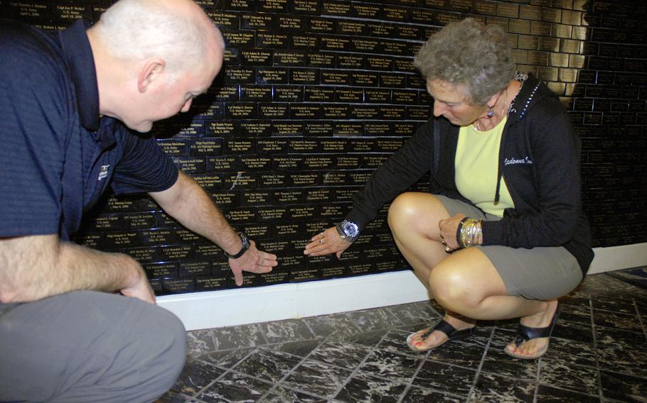 Ret. Col Steve Mahoney and his wife Yanny Mahoney bend down to touch the name of a young soldier who was killed when he served under their son, an Army lieutenant at the time. The Mahoney's visit the memorial to post-9/11 fallen troops at the Marines' Memorial Club and Hotel in San Francisco a few times a year. 