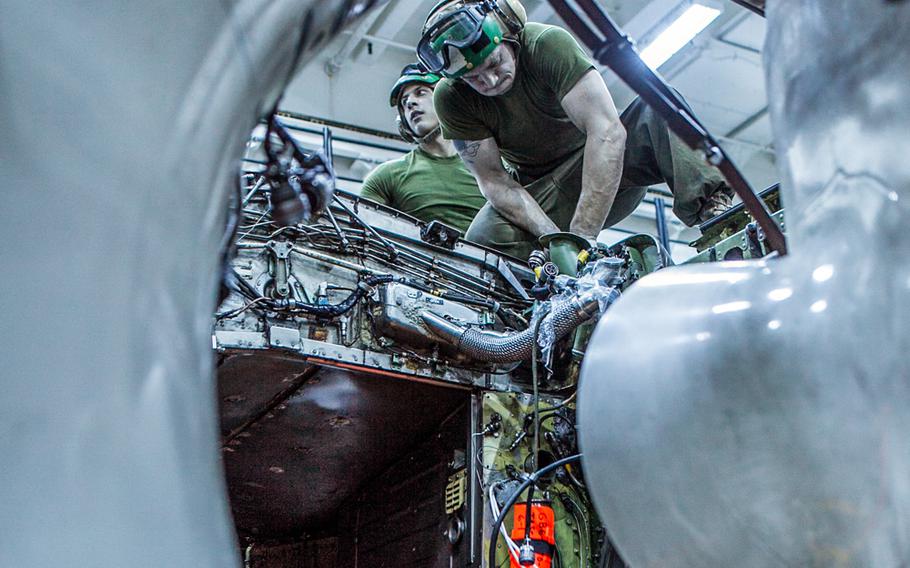 Cpl. Garret J. Madson, left, from Henderson, La., and Cpl. Josh L. Loudermeck, from Taylorsville, N.C., both airframe mechanics with Marine Medium Tiltrotor Squadron 265 (Reinforced), 31st Marine Expeditionary Unit, take out the engine of an AV-8B Harrier II jet inside the hangar bay aboard the USS Bonhomme Richard on Sept. 6, 2013.