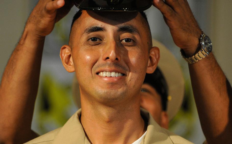 Chief Petty Officer Gabriel Martinez, a boatswain's mate, has his new cover place on his head during a chief petty officer pinning ceremony at Camp Lemonnier, Djibouti. Navy commands world-wide pinned about 4,600 sailors selected for E-7 last week to the rank of a chief petty officer.