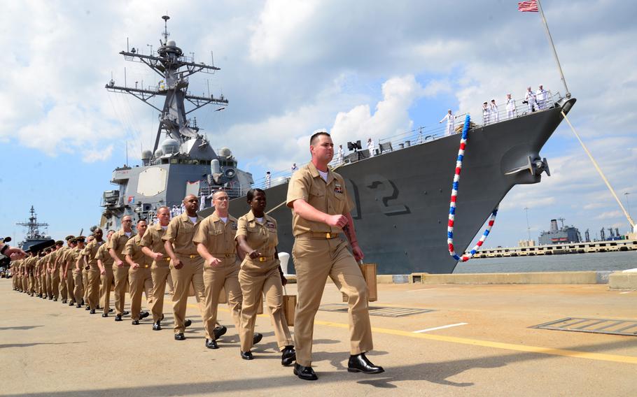 Chief selectees from USS Mahan sing "Anchors Away" as they march to their pinning ceremony held at the end of the pier in Norfolk, Va., on Sept. 13, 2013 .