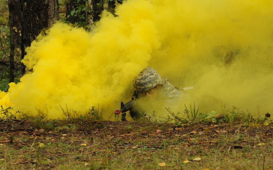 Partly concealed by smoke from a smoke grenade, Army 2nd Lt. Chunjiang Liao of the 21st Theater Sustainment Command's 16th Sustainment Brigade lies in the prone firing position Sept. 13, 2013, during testing for the Expert Field Medical Badge at Grafenwöhr, Germany.