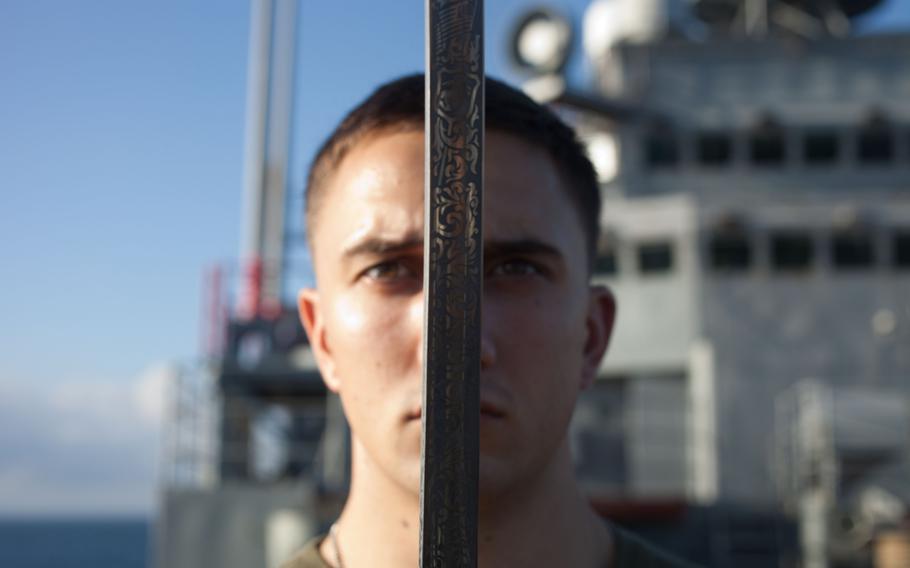 Cpl. Jacob A. Flury, with the 31st Marine Expeditionary Unit, executes a movement with a noncommissioned officer sword during a Corporals Course class on the bow of the USS Denver, Sept.14, 2013.