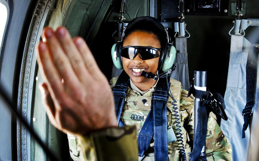 U.S. Army Spc. Joy Odom recites the oath to re-enlist from the back of a UH-60L Black Hawk helicopter during a mission over Laghman province, Afghanistan, Nov. 1, 2013.