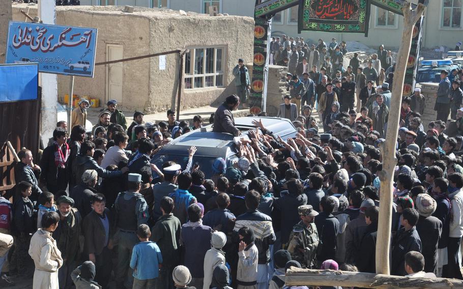 Afghans rush a van full of food to be handed out to the poor Thursday in Bamiyan, Afghanistan, in accordance with Ashura, one of the holiest days of the year for Shia Muslims.