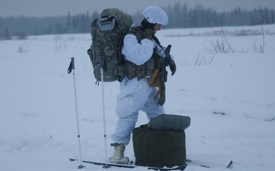 Staff Sgt. Bruce Henderson, an infantryman with 4th Infantry Brigade Combat Team (Airborne), 25th Infantry Division, secures his equipment in preparation to move after jumping from a C-130 Hercules on Dec. 12, 2013 at the Malemute Drop Zone at Joint Base Elmendorf-Richardson, Alaska. Henderson said the jump gave soldiers a chance to familiarize themselves with carrying arctic equipment while jumping from an aircraft.