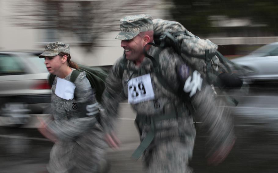 Senior Airman Alia Caudill and Master Sgt. Raymond Marsh, members of the 569th Security Forces Squadron, head toward the finish during an 87-mile relay, April 11, 2013, in remembrance of Army Capt., Emil Kapaun. Kapaun was a chaplain whose unit was forced to march 87 miles after its capture in the Korean War. His actions earned him the Medal of Honor, which President Barack Obama presented to his surviving family.
