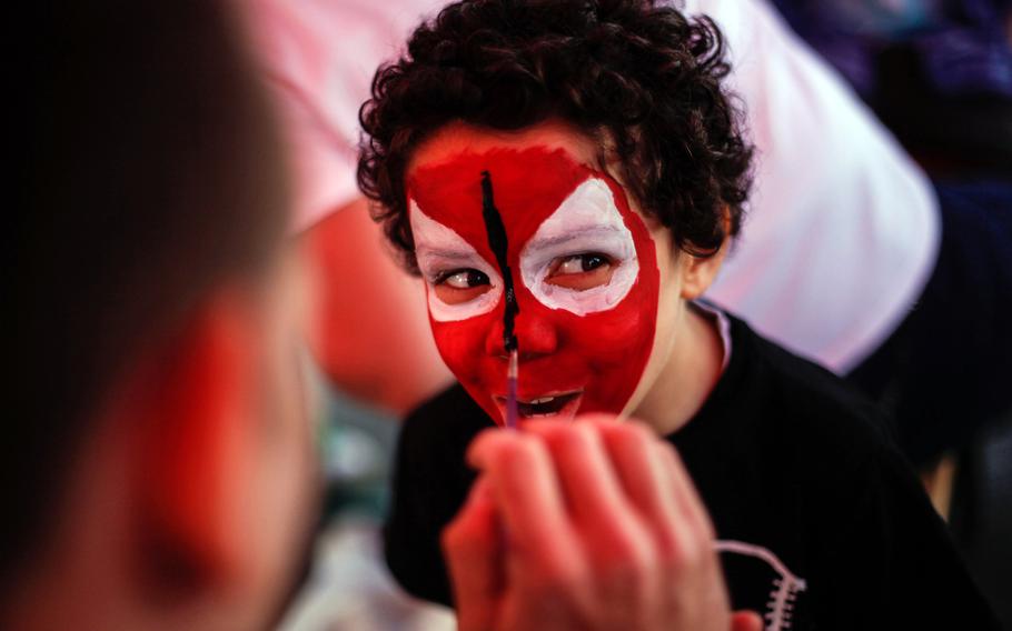 Tyler Warren, 5, smiles at his parents while a volunteer paints his face to look like Spiderman during an Independence Day event at the U.S. Army's Smith Barracks in Baumholder, Germany.