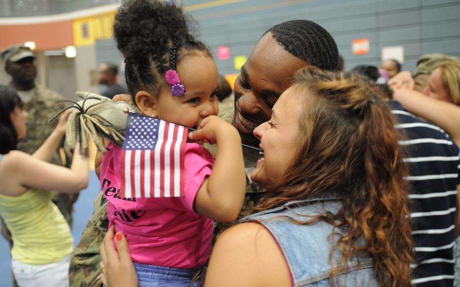 Staff Sgt. Herman Haynie, wife Rita and daughter Ila embrace during a redeployment ceremony in Bamberg, Germany, on Wednesday, July 31, 2013. Members of the 16th Sustainment Brigade spent nine months in Afghanistan, training Afghan forces.