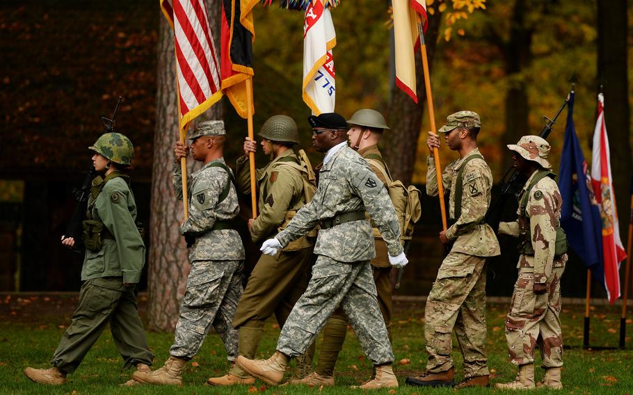 The 21st Theater Sustainment Command color guard, dressed in military uniforms from throughout the years, marches off the Panzer Kaserne parade field for a Veterans Day Observance in Kaiserslautern, Germany, Nov. 7, 2013.