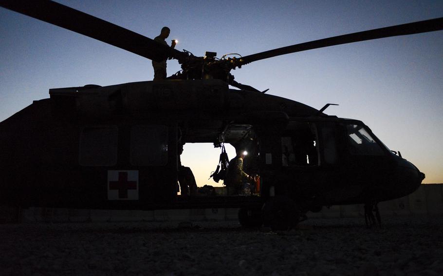 Crewmembers from 4th Platoon, Company C, out of Fort Riley, Kan., conduct post-flight maintenance checks on the helipad of Forward Operating Base Pasab, Afghanistan, after completing a medical evacuation mission on Oct. 22, 2013.