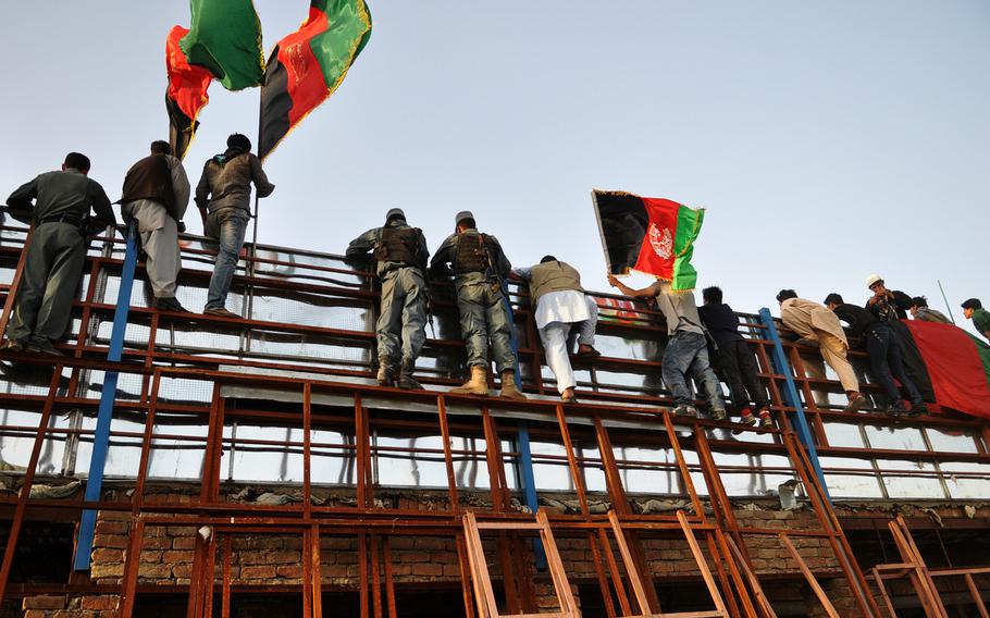 Fans who couldn't get tickets to the sold-out game pitting Afghanistan and Pakistan's soccer teams Tuesday, Aug. 20, 2013, scaled the walls for a peek at the action. The match was the first international held on Afghan soil in 10 years.