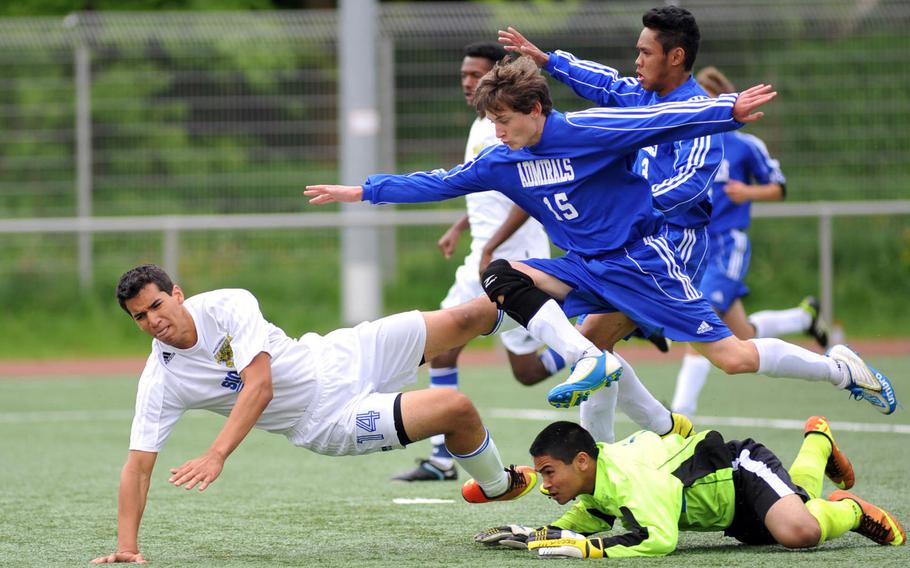 Everyone goes flying over Rota keeper Jonas Camacho including Sigonella's Antonio Garcia-Diaz and teammates John Gartland, center, and Chester Decastro in a Division III match-up on May 21, 2013, at the DODDS-Europe soccer championships.