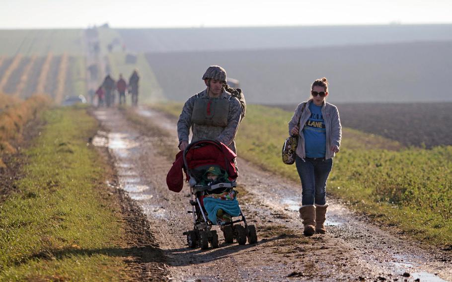 After parachuting onto a farmer's field Monday, Dec. 16, 2013, outside the German town of Alzey, Capt. Michael Wetlesen of the Air Force's 435th Contingency Response Group was met by his wife, Samantha, and son Michael Jr., who he pushed back to the rally point in his stroller.