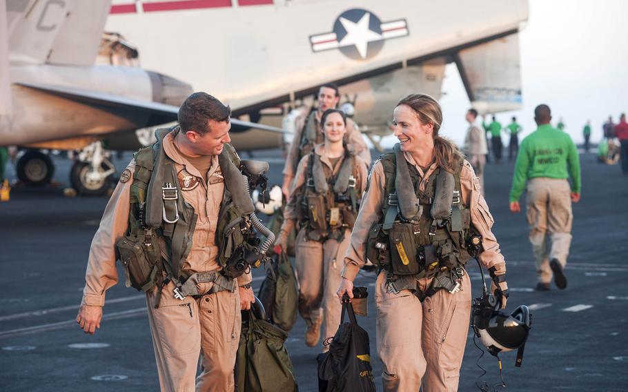 Capt. Sara Joyner, commander, Carrier Air Wing 3, of Hoopers Island, Md.; and Lt. Cmdr. Eddy DePuy, of Tallahassee, Fla., leave an E-2C Hawkeye, assigned to the "Seahawks" of Airborne Early Warning Squadron 126, on the flight deck of the aircraft carrier USS Harry S. Truman while sailing the Gulf of Oman Dec. 14, 2013.