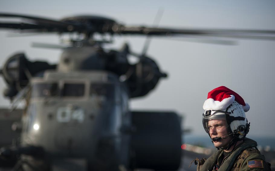 ARABIAN GULF (Dec. 19, 2013) Naval Aircrewman (Helicopter) 3rd Class Tyler Abbott, assigned to the Blackhawks of Helicopter Mine Countermeasures Squadron (HM) 15, waits while mail is unloaded from an MH-53E Sea Dragon helicopter on the flight deck of the aircraft carrier USS Harry S. Truman (CVN 75). Harry S. Truman, flagship for the Harry S. Truman Carrier Strike Group, is deployed to the U.S. 5th Fleet area of responsibility conducting maritime security operations, supporting theater security cooperation efforts and supporting Operation Enduring Freedom. (U.S. Navy photo by Mass Communication Specialist Seaman Karl Anderson/Released)