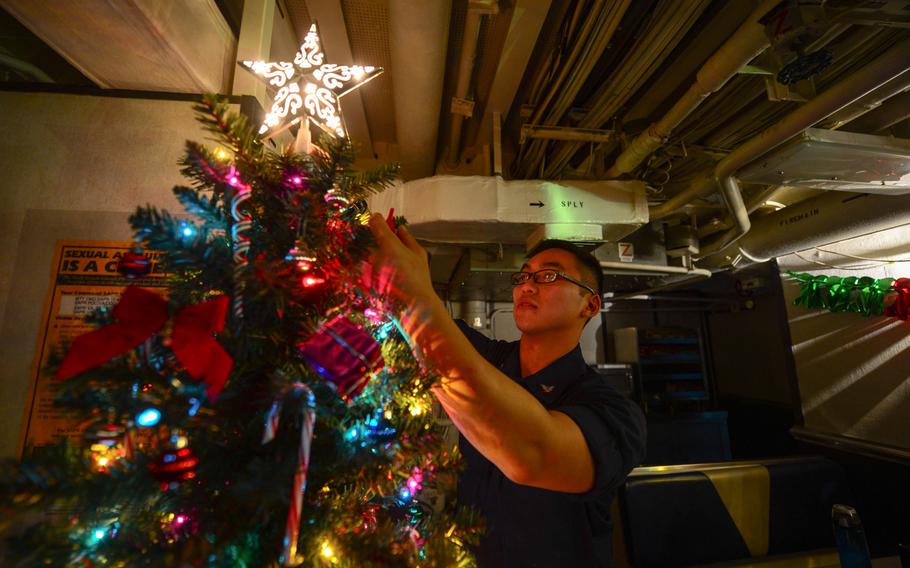 Culinary Specialist 3rd Class Haidavid Tran decorates a Christmas tree on the mess decks aboard the guided-missile cruiser USS Monterey  Dec. 15, 2013. Monterey is deployed in the Mediterranean Sea. 

