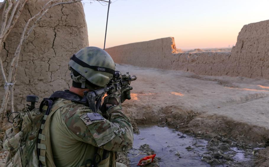 A Special Forces soldier scans the area as Afghan National Army commandos conduct clearance of Mandozai village, Maiwand district, Kandahar province, Afghanistan, on Dec. 27, 2013.