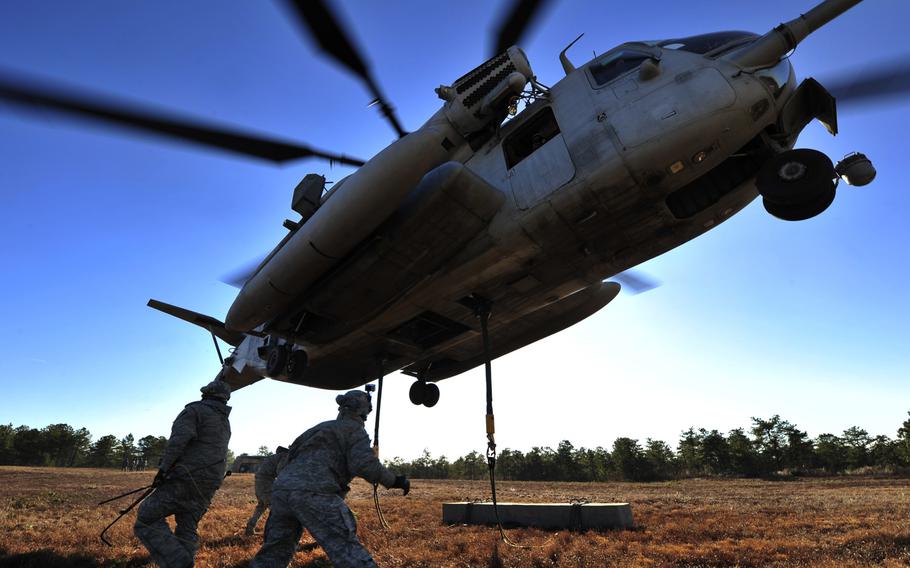 U.S. Air Force airmen from the 621st Contingency Response Wing, Joint Base McGuire-Dix-Lakehurst, N.J., clear the area after attaching a training block to a U.S. Marine Corps CH-53E Super Stallion helicopter assigned to Heavy Helicopter Squadron 772 at JBMDL, on Jan. 9, 2014.