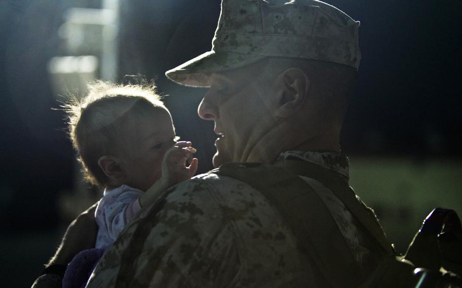 Sgt. Jeremy Speacht, a glasswave operator with I Marine Expeditionary Force (Forward), from Pottsville, Pa., holds his niece moments before departing Camp Pendleton, Calif., on his way to Afghanistan on Jan. 13, 2014.