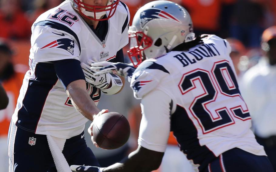 New England Patriots quarterback Tom Brady (12) hands of to New England Patriots running back LeGarrette Blount (29) during the first half of the AFC Championship NFL playoff football game against the Denver Broncos in Denver, Sunday, Jan. 19, 2014. (AP Photo/Julie Jacobson)