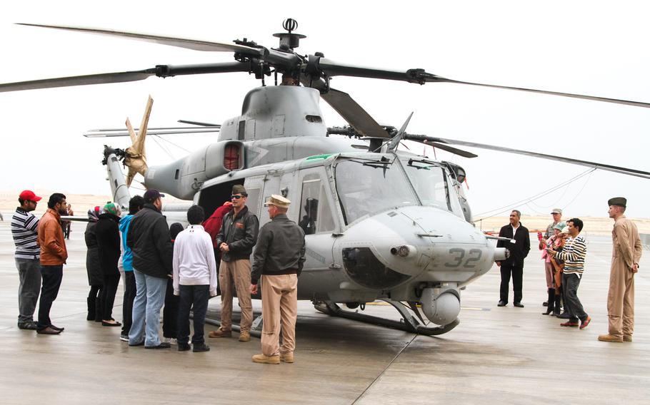 U.S. servicemembers tell visitors about the UH-1Y Huey Venom at the Bahrain International Airshow  Jan. 18, 2014.
