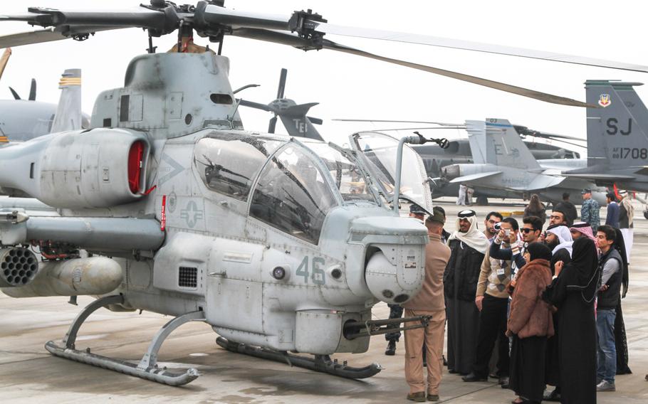 U.S. servicemembers tell visitors about the AH-1Z Viper helicopter on display at the Bahrain International Airshow on Jan. 18, 2014.
