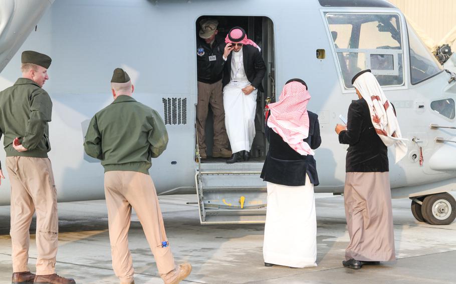 U.S. servicemembers escort visitors on a tour of the MV-22 Osprey on display at the Bahrain International Airshow  Jan. 18, 2014. The MV-22 Osprey was one of several U.S military aircraft on display at the air show.